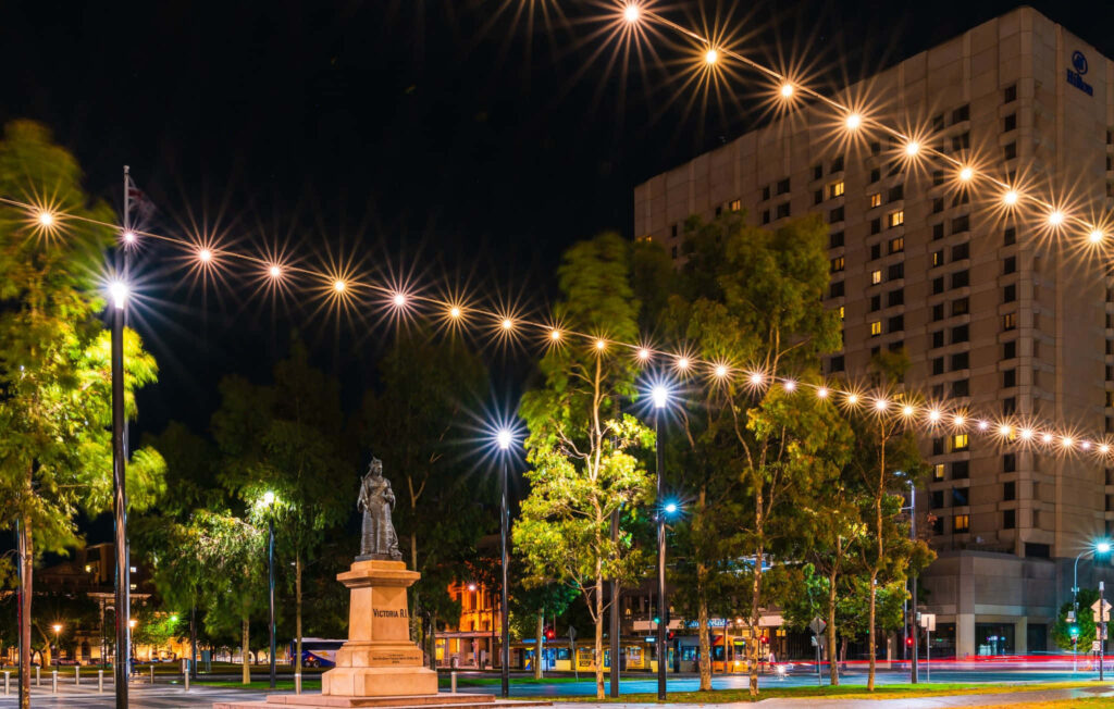 Adelaide Victoria Square night view with illuminated Queen Victoria statue vibrant cityscape Wallpaper