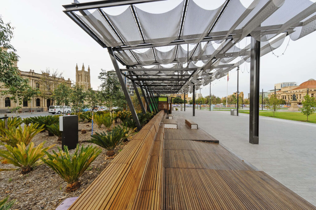 Adelaide Victoria Square modern urban design with wooden seating historic buildings and greenery Wallpaper