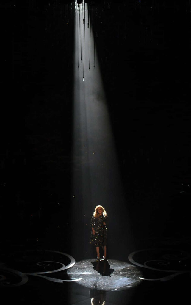 Adele's Iconic Stage Performance: Dramatic Spotlight Wallpaper