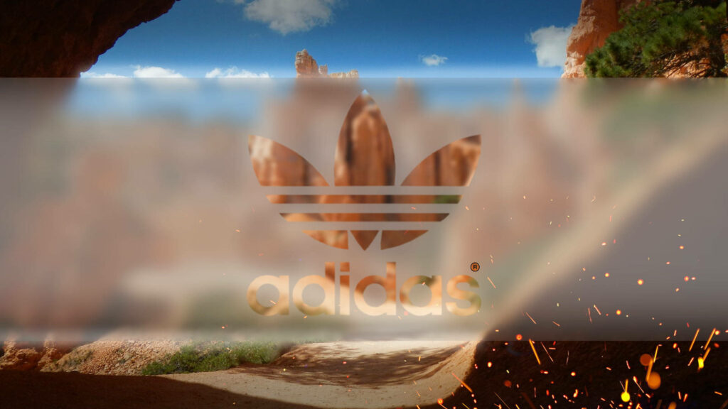 Adidas logo on vibrant desert landscape with rocky formations and dynamic natural light effects Wallpaper