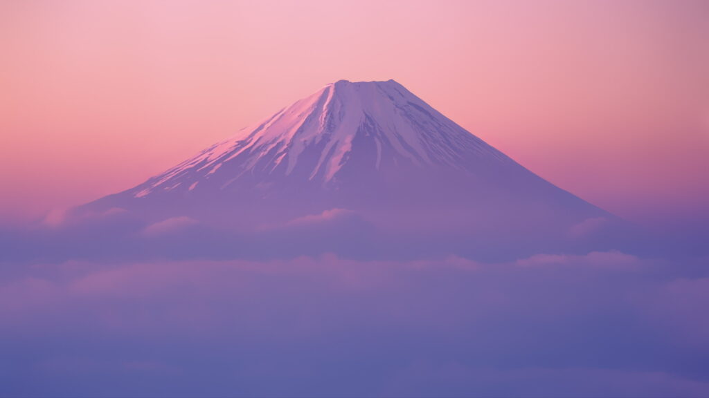 Mount Fuji snow-capped peak above clouds at sunset with pink lavender sky serene landscape wallpaper
