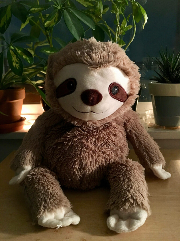 Cute and Cuddly Light Brown Baby Sloth Toy with Endearing Dark Patched Eyes – Lovely Baby Sloth Background Snapshot Wallpaper