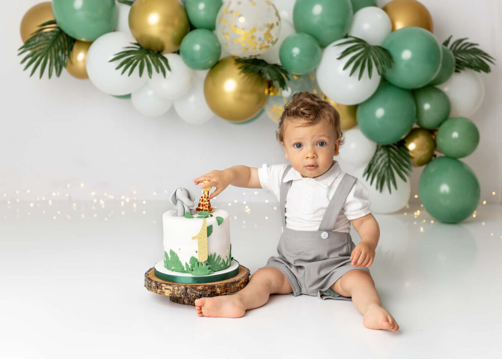 Adorable Baby in Suspenders Reaches for Colorful Cake Wallpaper