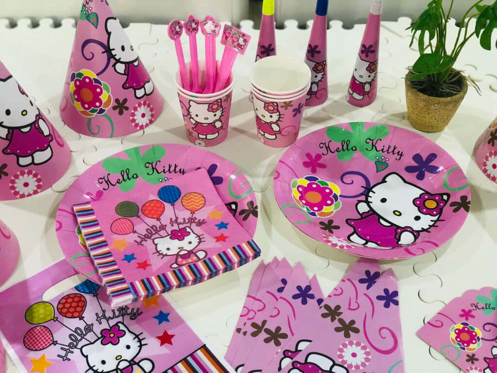 Cheerful Hello Kitty Party Decor: Plates, Cups, and Balloons Wallpaper