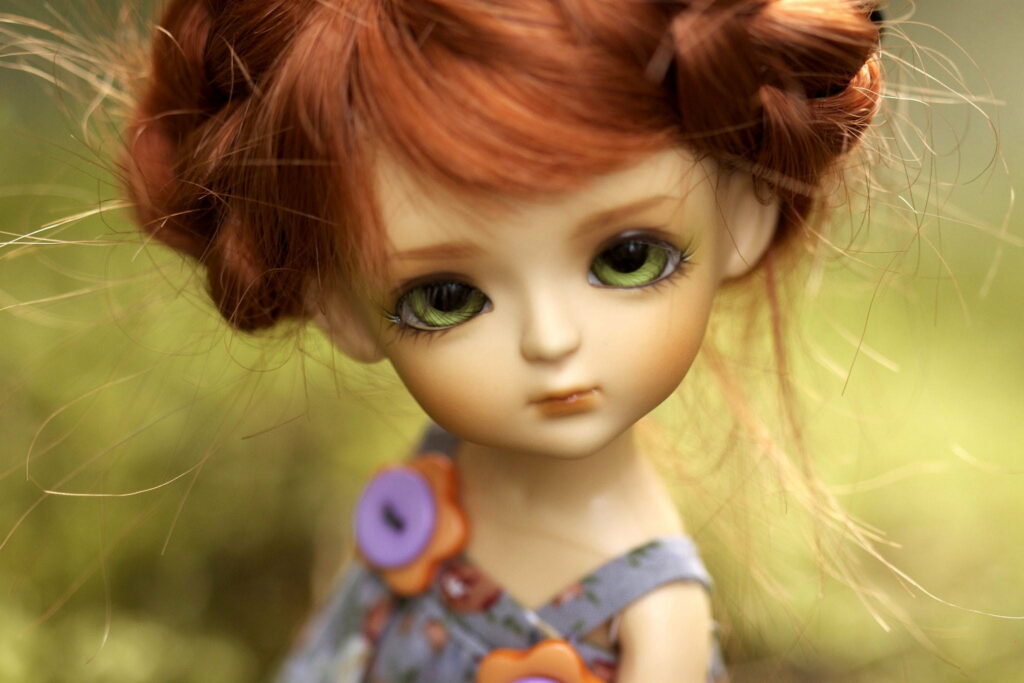 Close-up of ball-jointed doll with red hair green eyes floral buttons dreamy green bokeh background Wallpaper