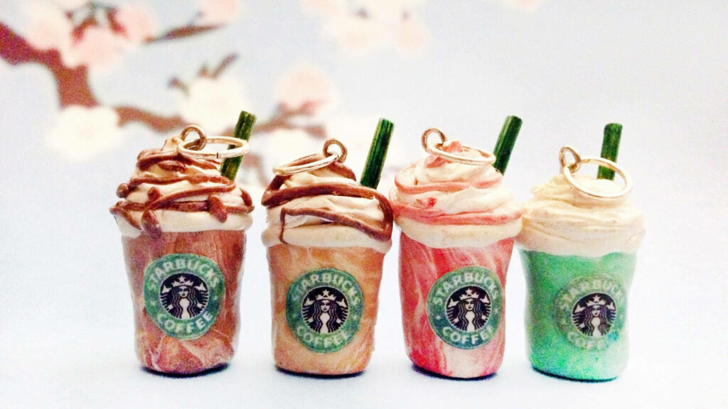Starbucks drink keychains in pastel background with floral accents charming wallpaper design