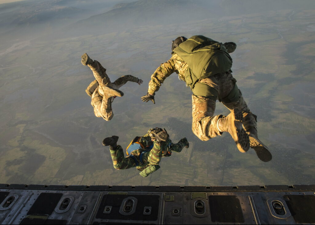 Leap of Valor: Aerial Parachute Brigade Descending into the Expanse Wallpaper