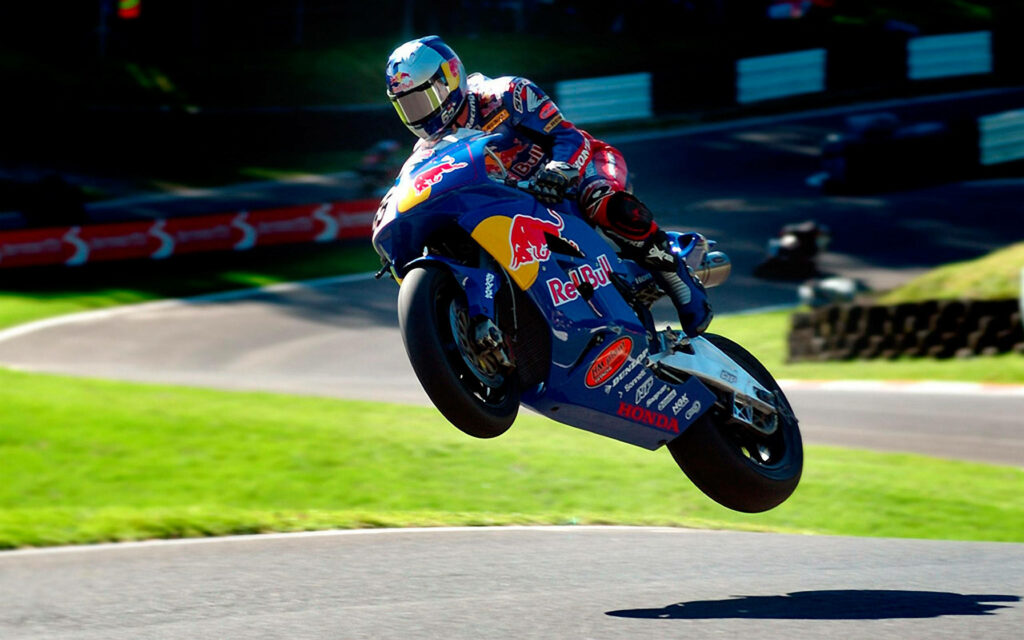 Adrenaline-Filled Motorcycle Racing Wallpaper: Red Bull Honda Leap