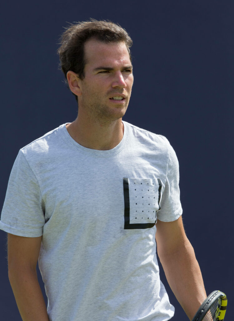 Adrian Mannarino focused holding tennis racket ready on court dynamic sports wallpaper background