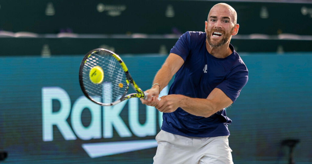 Adrian Mannarino intense tennis swing on court dynamic sports wallpaper background image