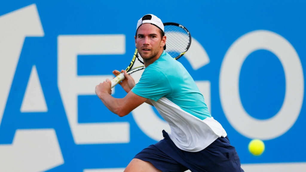 Adrian Mannarino focused on tennis court preparing to return shot in competitive match wallpaper