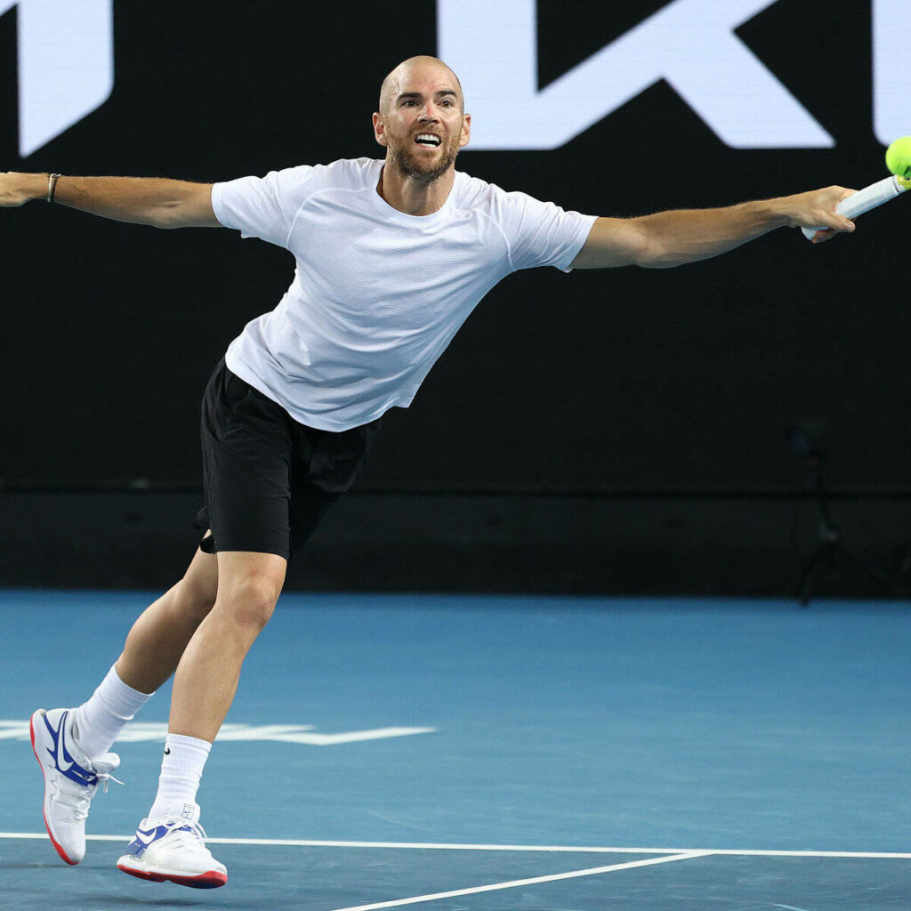 Adrian Mannarino mid-action tennis match showing agility focus dynamic sports wallpaper background