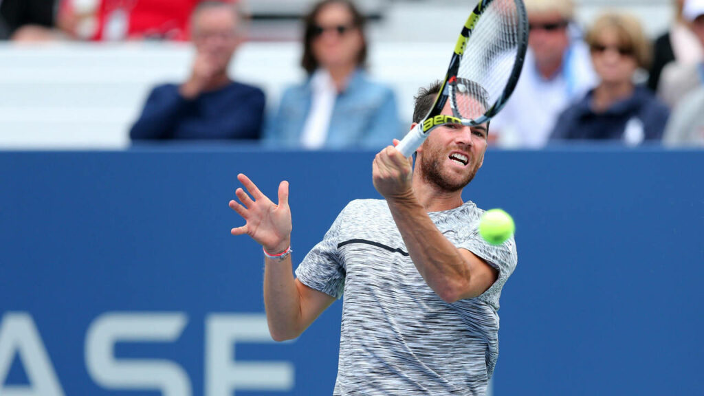 Adrian Mannarino mid shot hitting tennis ball intense match dynamic tennis fan wallpaper background