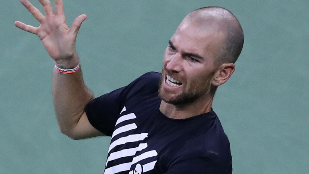 Adrian Mannarino raising racket with intense focus during competitive tennis match wallpaper background