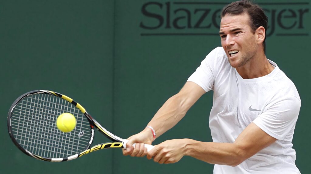 Adrian Mannarino focused intense tennis shot mid match dynamic sports wallpaper background