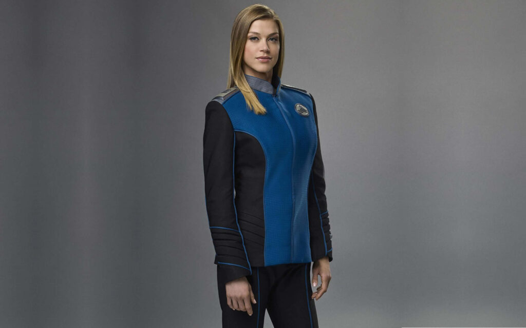 Adrianne Palicki in futuristic uniform on sleek gray background strong confident wallpaper