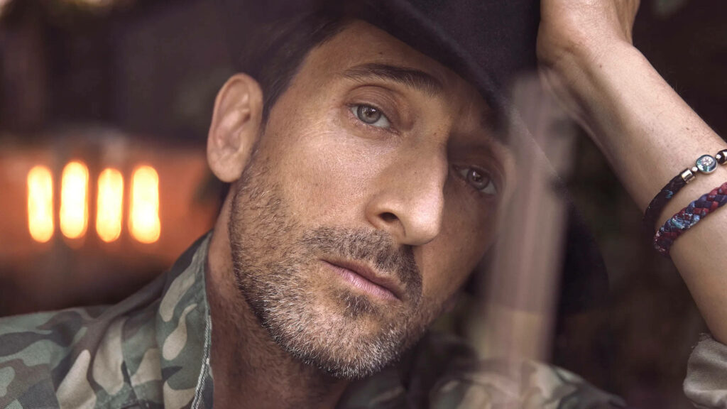 Close-up of award-winning actor Adrien Brody with contemplative expression and rugged style wallpaper