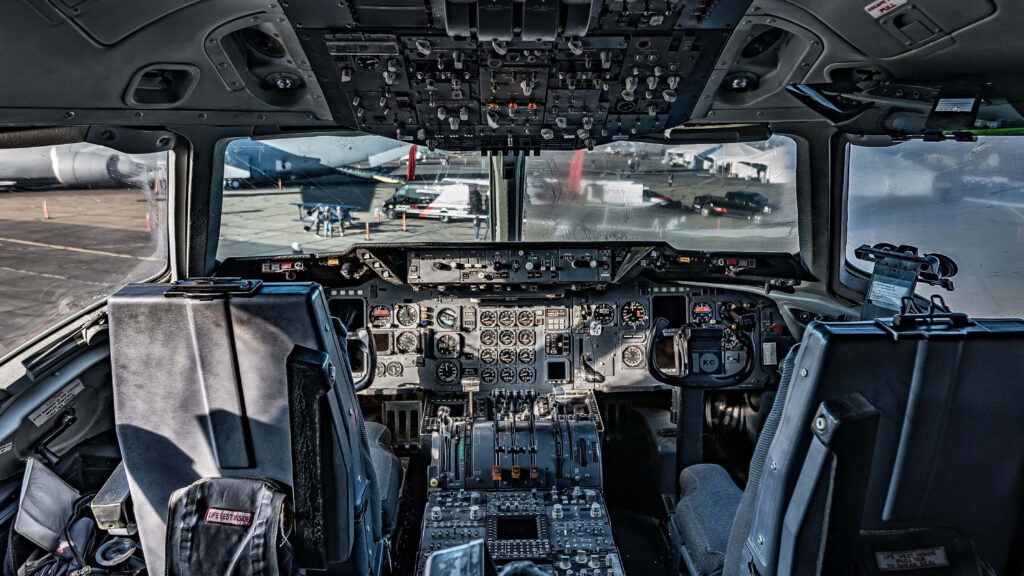 Commercial airplane cockpit with detailed switches dials controls illuminated by daylight wallpaper
