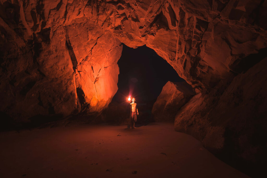 Adventurous Cave Exploration: A Torch-Lit Journey into Darkness Wallpaper