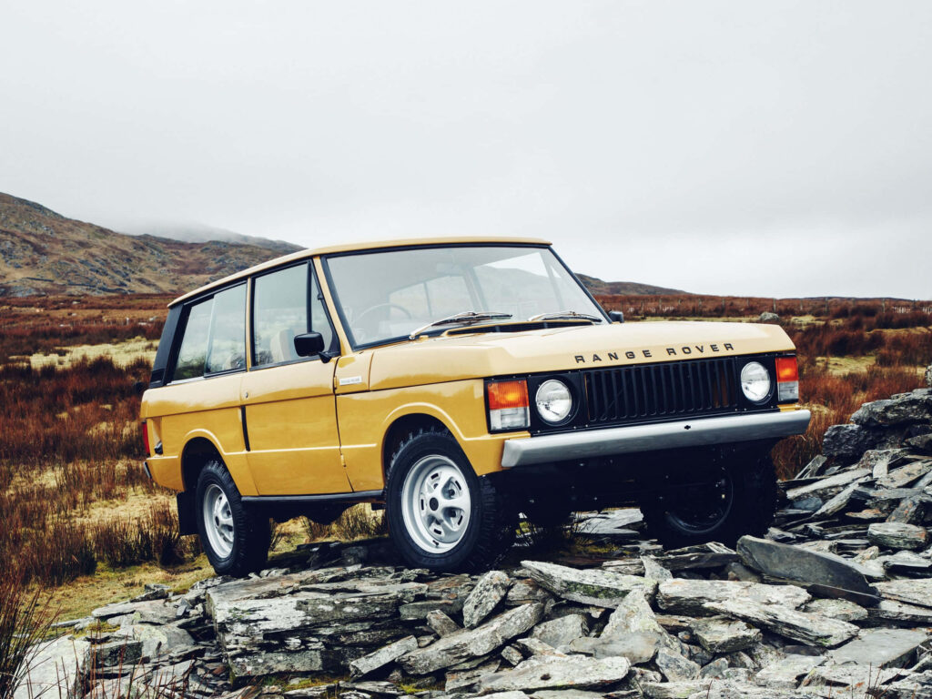 Classic Yellow Range Rover on Rugged Rocks - Adventure Wallpaper