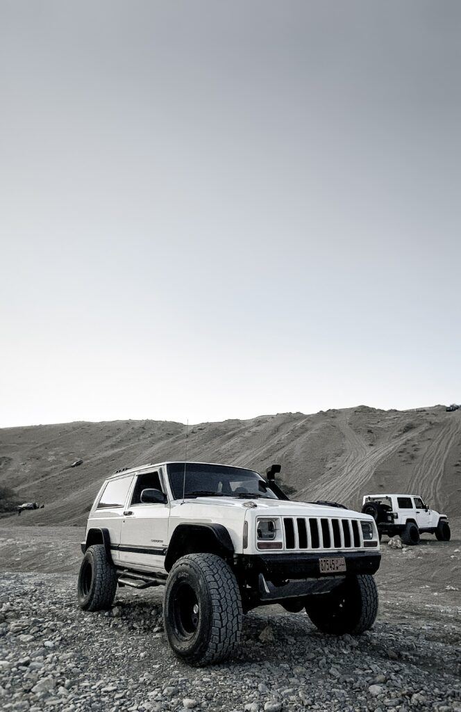 Adventure Awaits: Rugged White Jeep Cherokee on Rocky Terrain Wallpaper
