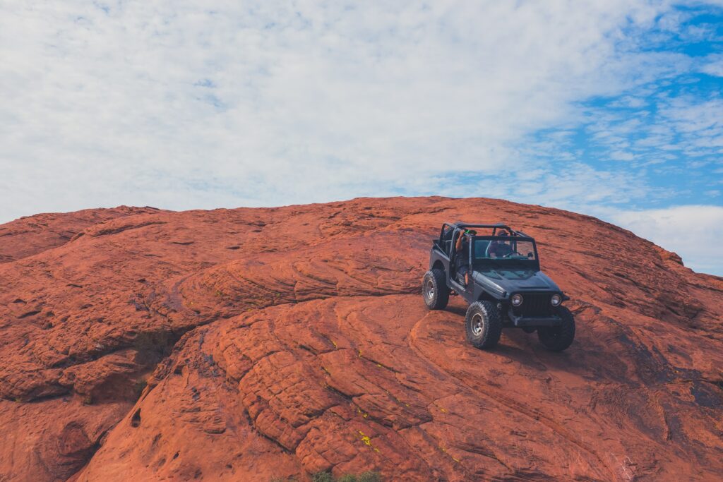 Adventure SUV on Red Rock Hill - Rugged Desert Landscape Wallpaper