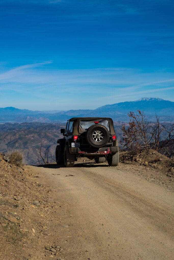 Adventure Awaits: Black SUV in Rugged Mountain Terrain Wallpaper