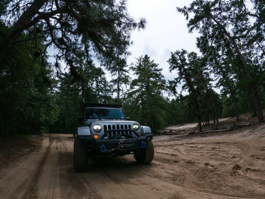 Gray Jeep Wrangler Off-Roading in Dense Forest Wallpaper