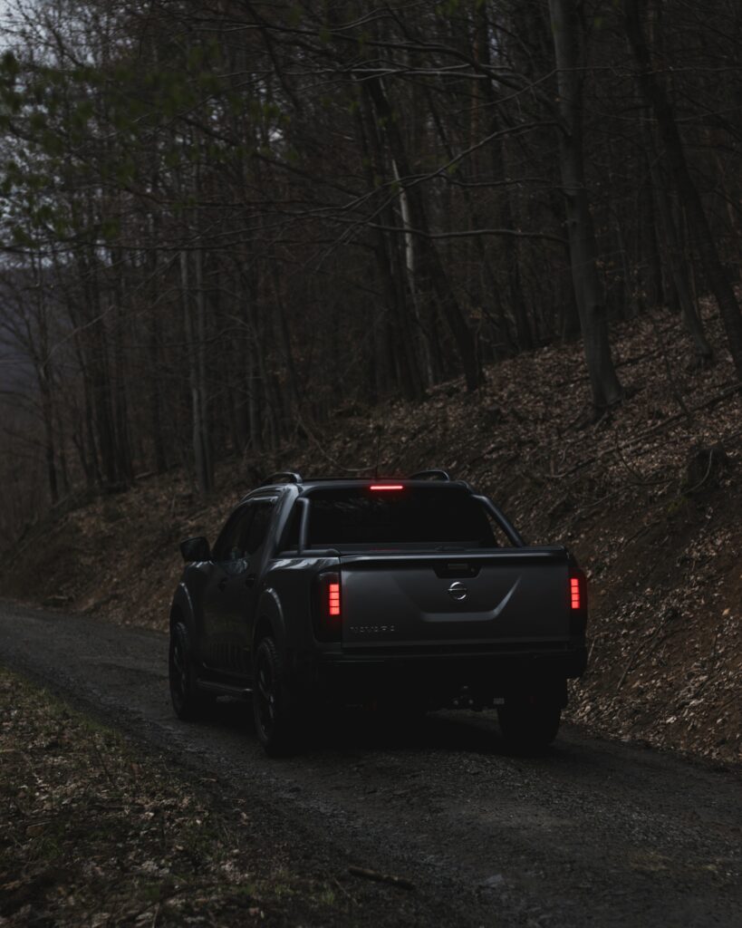 Gray Nissan Navara Pickup Truck on Rugged Forest Road Adventure Wallpaper