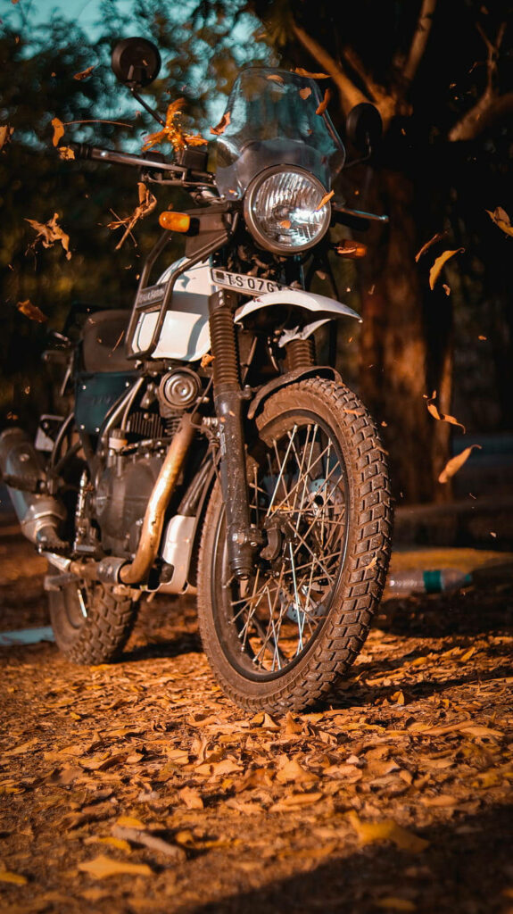 Adventure Awaits: Himalayan Motorcycle Wallpaper with Autumn Leaves