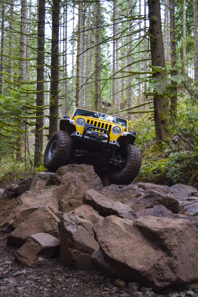Rugged Jeep Adventure: Off-Roading Through Rocky Forest Terrain Wallpaper