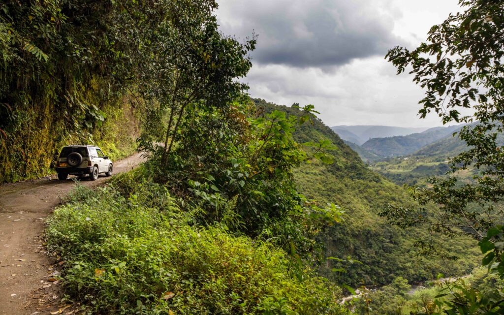 Adventurous Car Journey Through Lush Mountainous Landscape Wallpaper