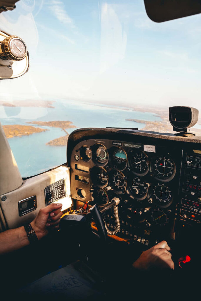 Aerial view from aircraft cockpit showing flight instruments and scenic islands over blue waters Wallpaper