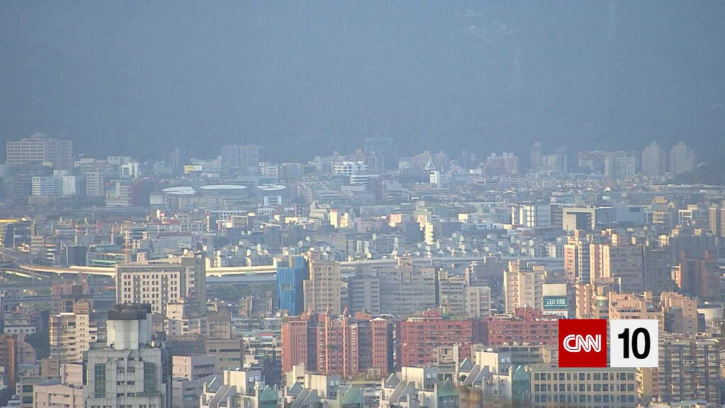 Aerial Cityscape Wallpaper with CNN 10 Logo - Hazy Sky Background