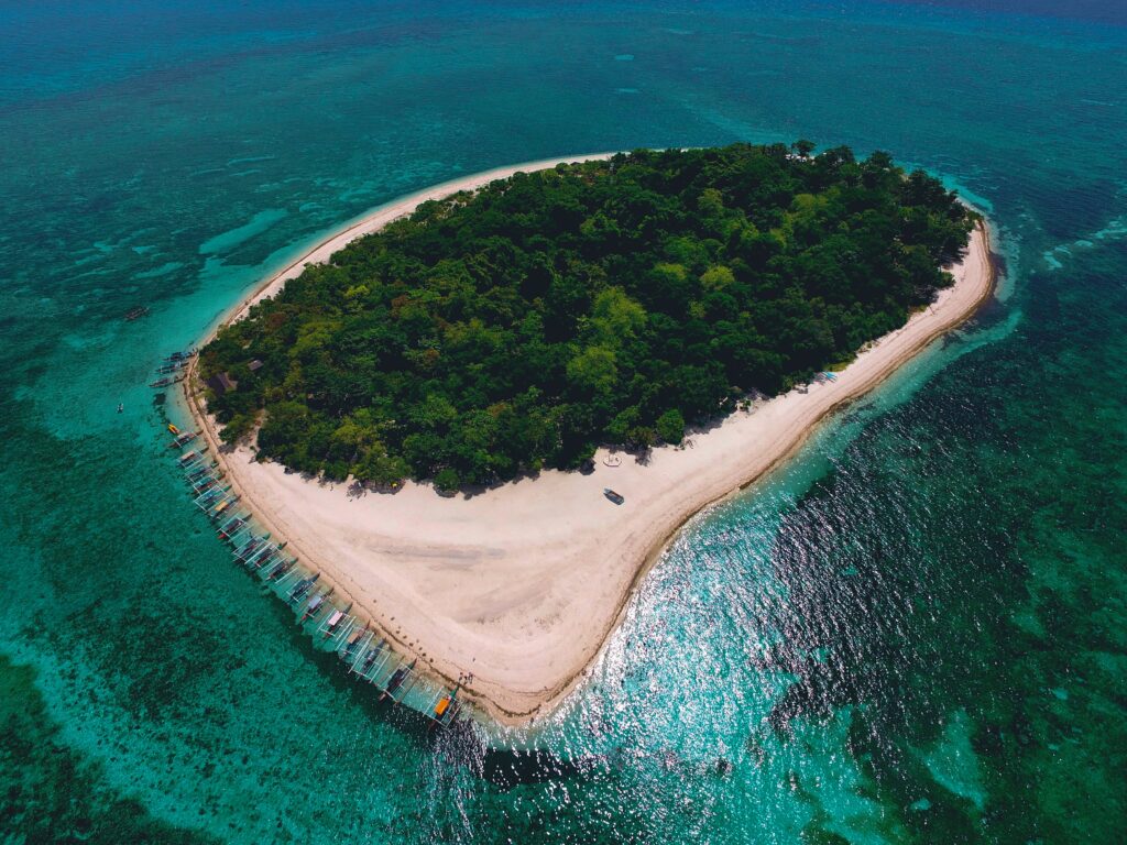 Aerial view of lush tropical island with white sandy beaches and turquoise waters Philippines wallpaper