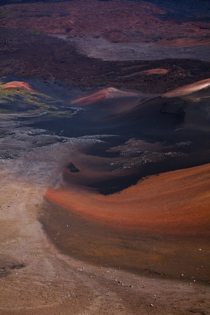 Aerial view of volcanic desert landscape with rust red black sands and dynamic earth tones wallpaper