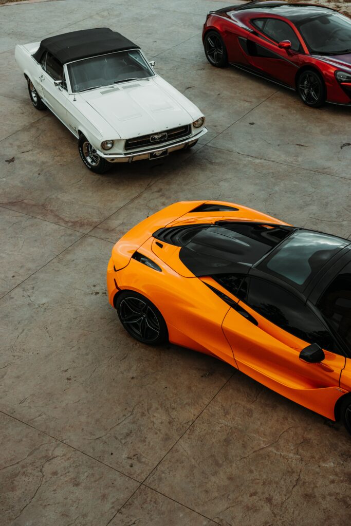 Vibrant Aerial View of Three Cars Parked on Concrete Surface Wallpaper