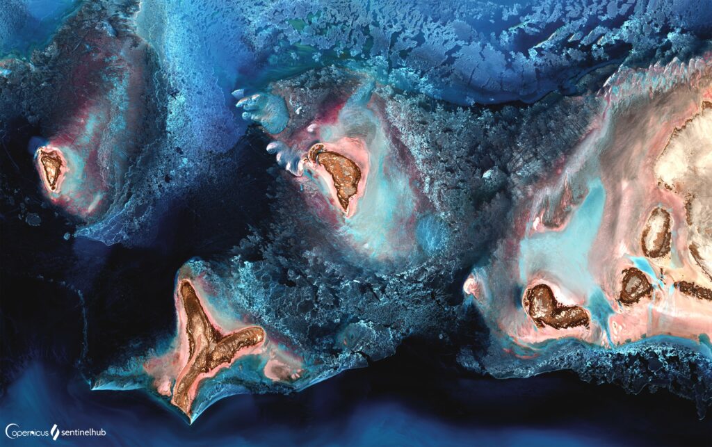 Aerial view of Caspian Sea with blue waters and textured sandy rocky earth relief wallpaper background