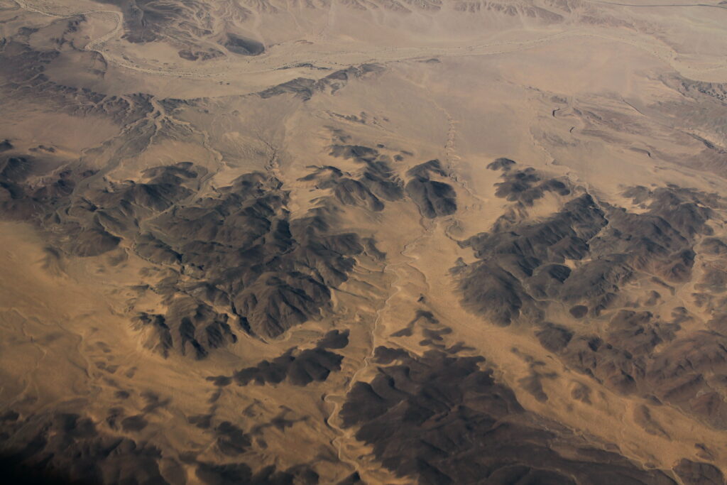 Aerial view of rugged brown desert mountains with textured relief and natural earthy patterns Wallpaper