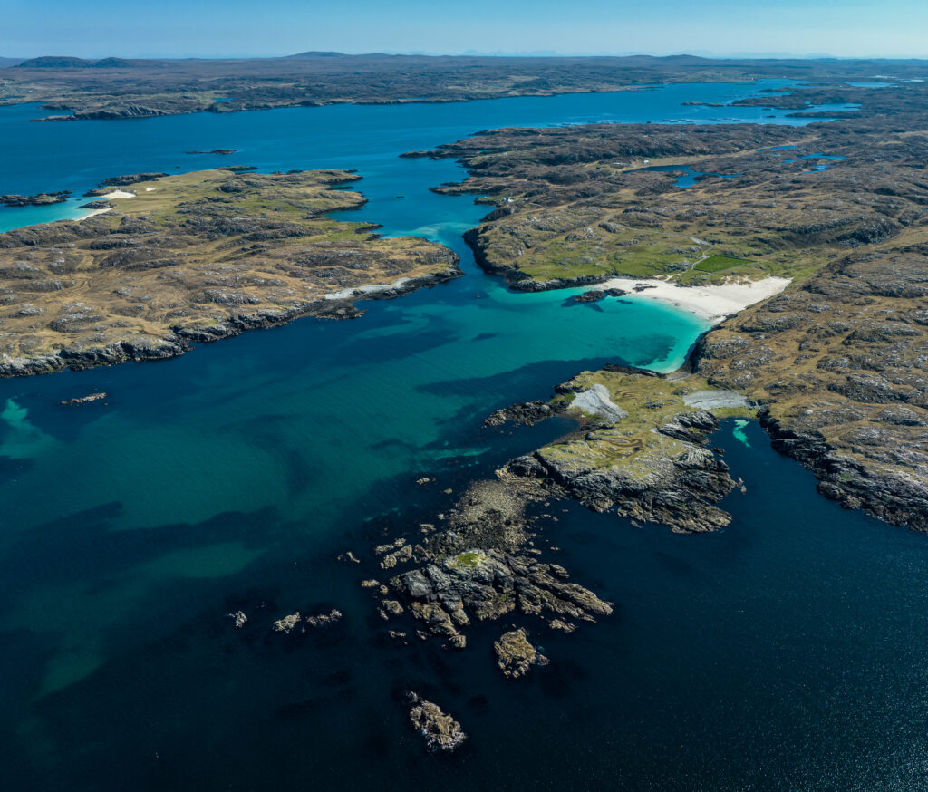 Aerial view of rugged islands with turquoise shallows and deep blue sea coastal landscape wallpaper