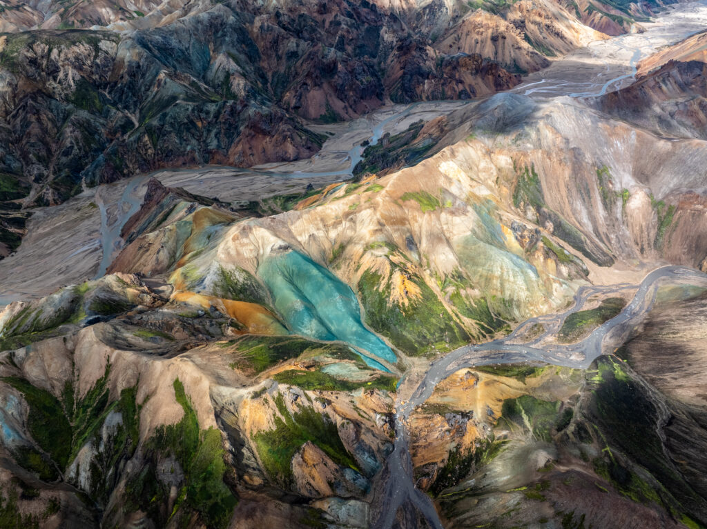 Aerial view of rugged mountains with vivid green turquoise gold and brown layered textures wallpaper