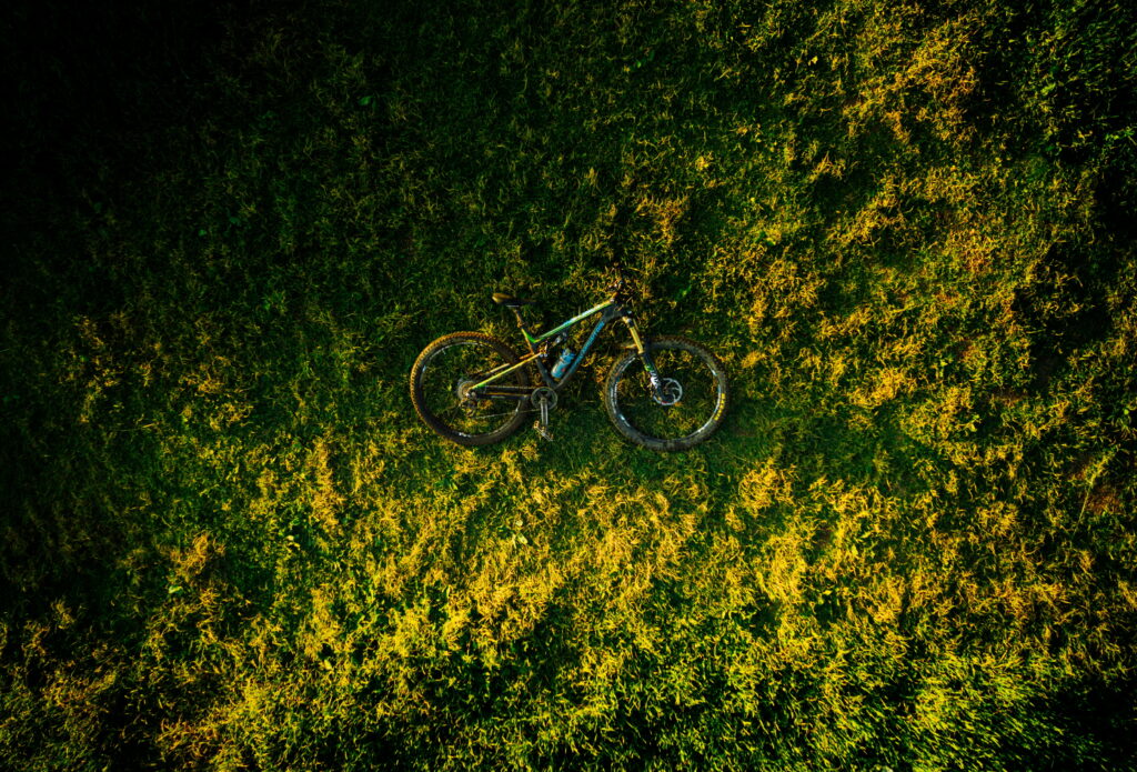 Stunning Aerial Perspective: Captivating Bike Amidst Lush Green Grass - HD Wallpaper