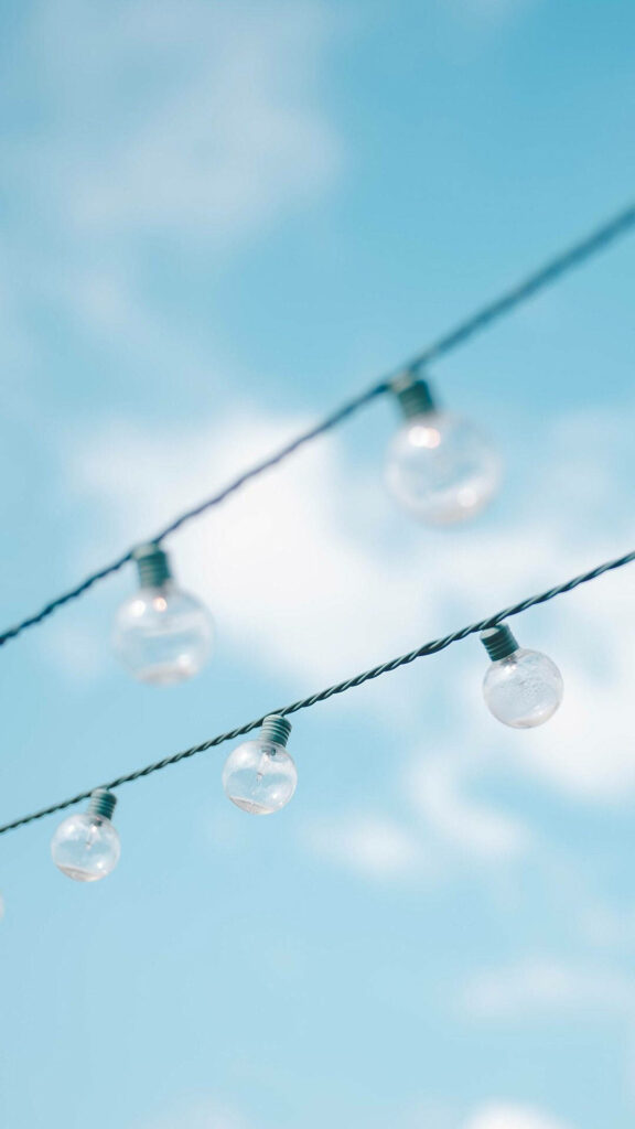 Enlightened Sky: Mesmerizing Light Bulbs Amidst Serene Baby Blue Cloudscape Wallpaper