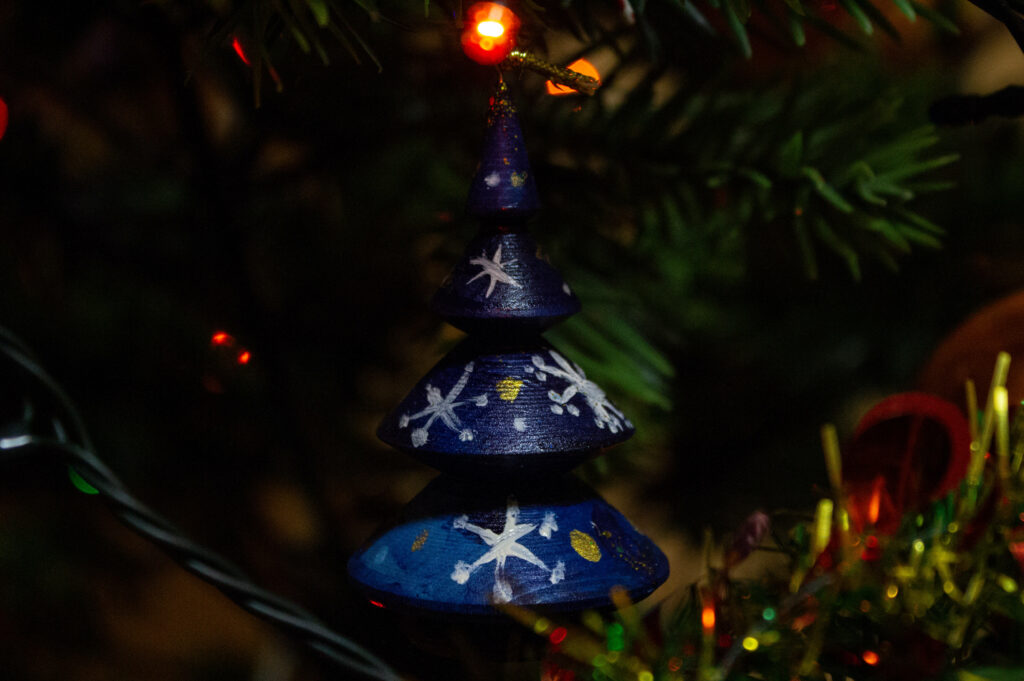 Starry Delight: A Mesmerizing Handcrafted Blue Christmas Ornament Shining on the Festive Tree Wallpaper