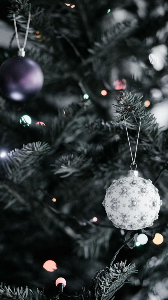 Festive Delight: Capturing the Charm of a Adorable Christmas Bauble amidst a Vibrant Blurred Evergreen Backdrop Wallpaper
