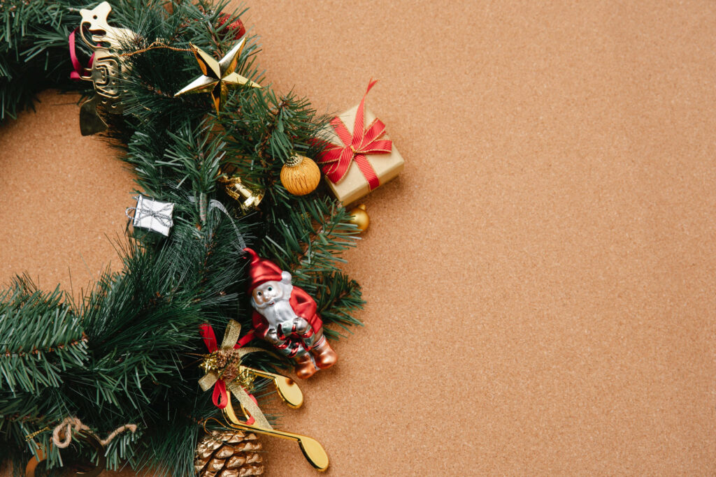 Festive Elegance: A Stylish Christmas Wreath Adorns a Rich Brown Background Wallpaper