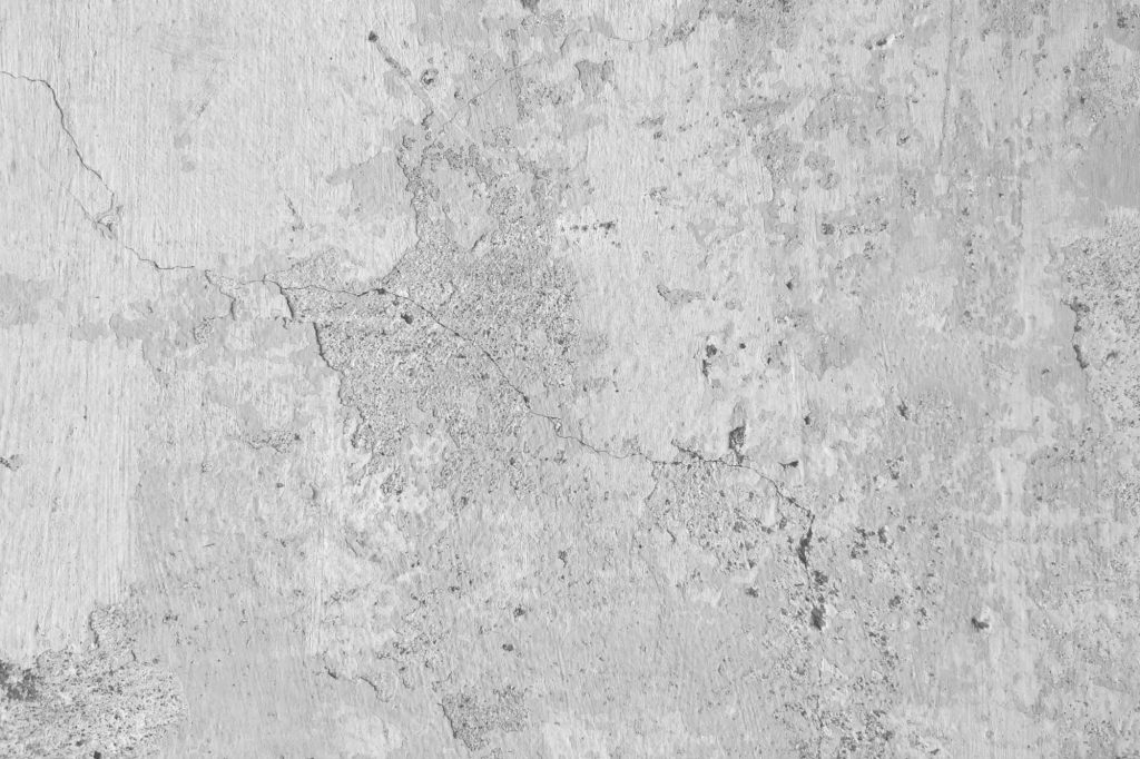 Weathered concrete wallpaper with realistic cracked cement texture in neutral grey tones
