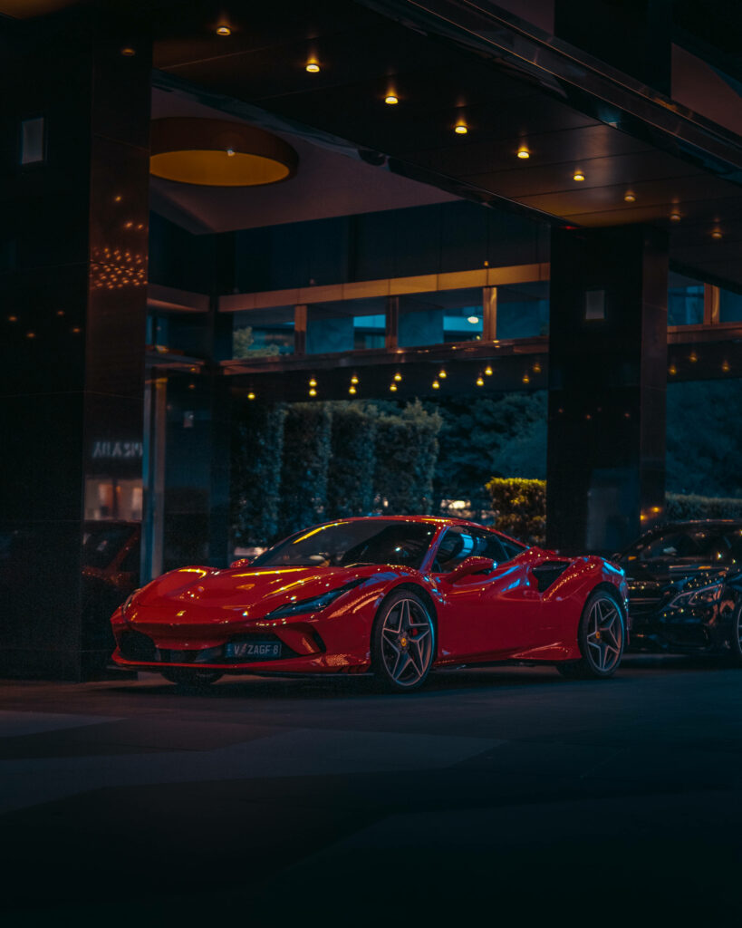Gorgeous Illumination: Stylish Ferrari F8 Tributo in Vibrant Red, Embracing the Glowing Cityscape Wallpaper