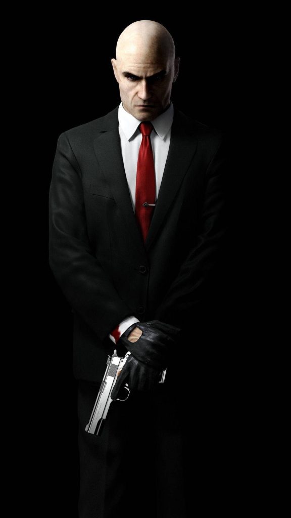 Agent 47 Hitman wallpaper in sharp suit red tie holding silver pistol against black background