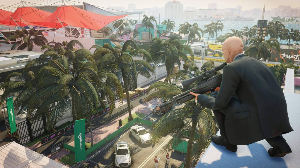 Agent 47 in suit aims sniper on Miami rooftop overlooking race track vibrant palm trees stealth game Wallpaper